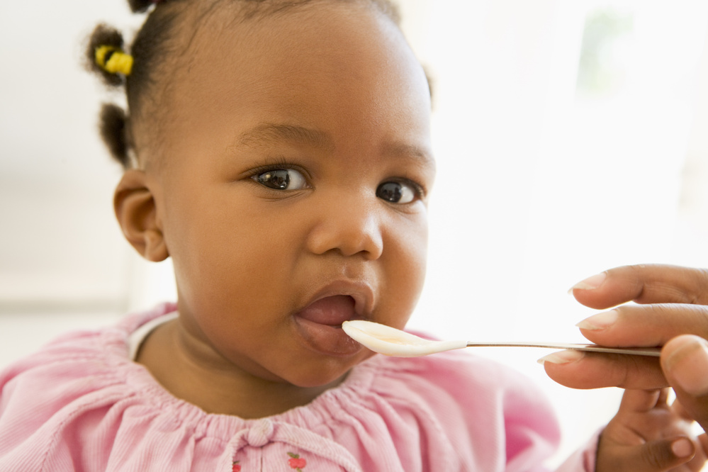 Mother Feeding Baby Food to Baby