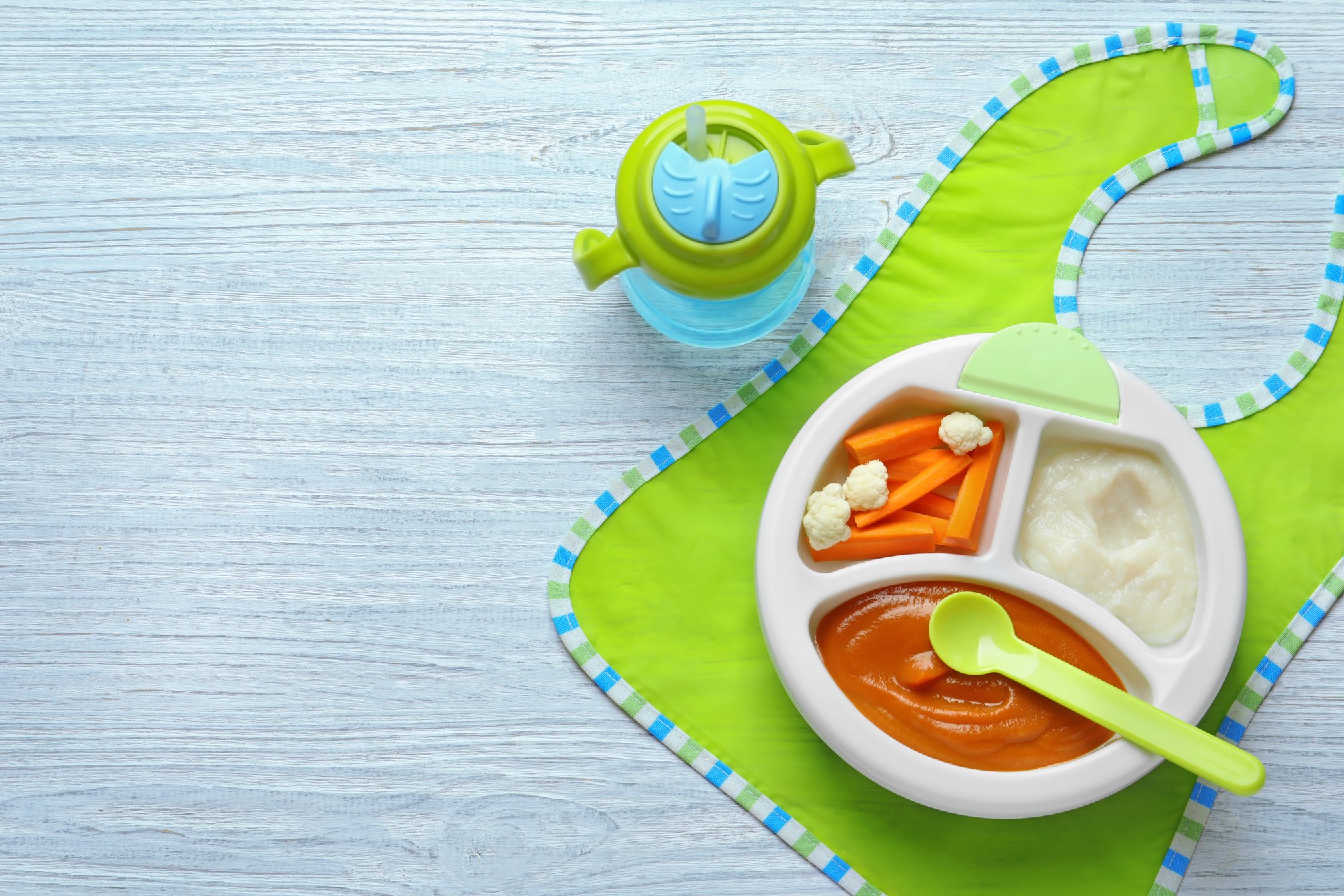 Section Plate with Baby Food on Wooden Background